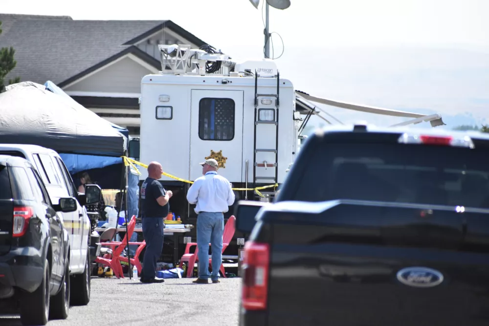 Investigators work at the scene Tuesday, Aug. 25, 2026, where a family was killed and a house burned in Billings, Mont. (AP Photo/Matthew Brown)