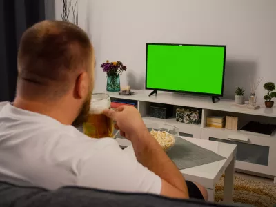 Man Watching Green Screen TV at home. Drink Beer Eating Popcorn. Over the Shoulder Back view. Chroma key.