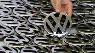 FILE PHOTO: An employee poses while holding an emblem for a Volkswagen Golf car during a photocall in a production line at the Volkswagen headquarters in Wolfsburg November 14, 2008. REUTERS/Christian Charisius/File Photo