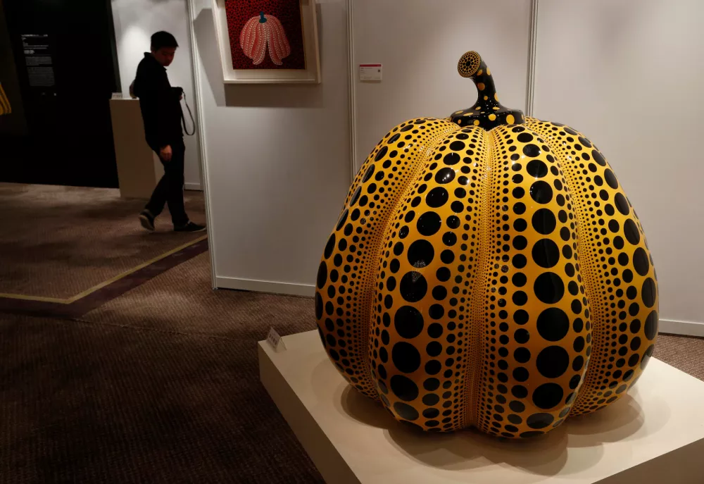 FILE - A man walks past a work " Pumpkin " by Japanese artist Yayoi Kusama during the Ravenel auction press preview in Hong Kong Friday, Nov. 23, 2012. (AP Photo/Vincent Yu, File)