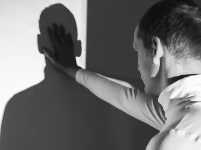 Man back view, touching his shadow on the wall, photo in black and white