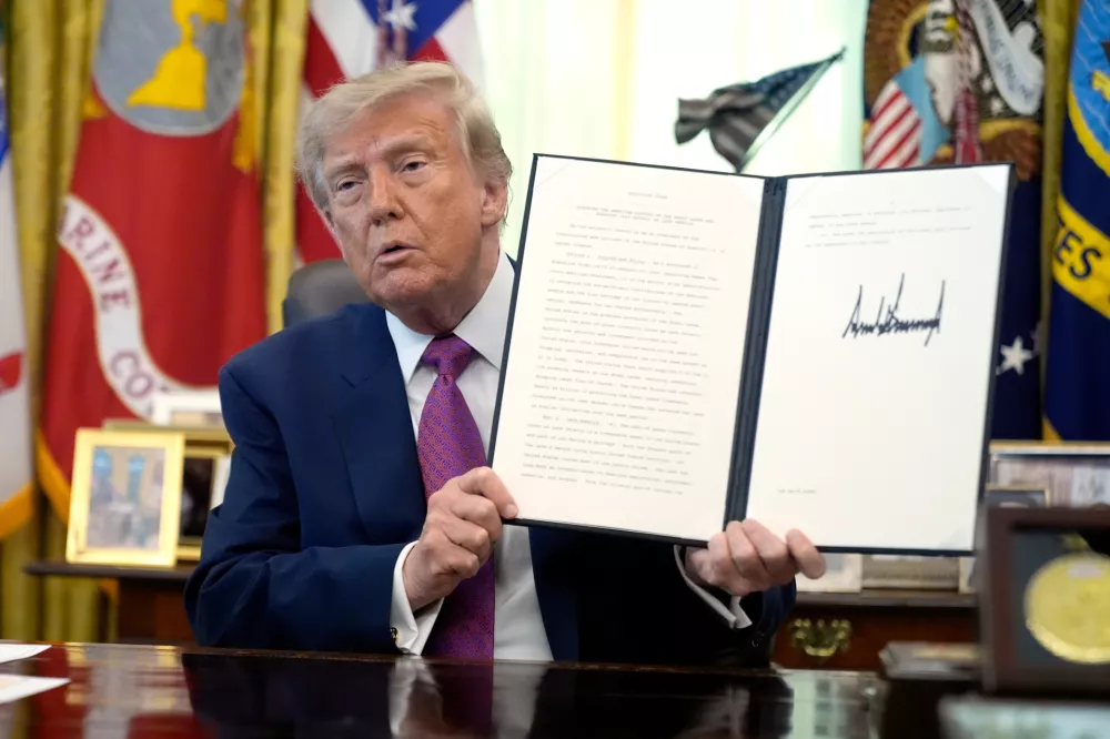 President Donald Trump holds up a signed executive order in the Oval Office of the White House, Thursday, Aug. 27, 2026, in Washington. (AP Photo/Manuel Balce Ceneta)