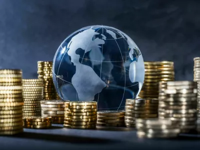 Globe and stack with coins. Money makes the world go round / Foto: Gopixa
