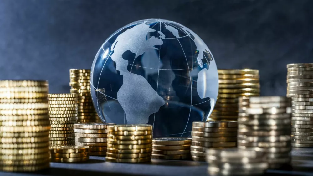 Globe and stack with coins. Money makes the world go round / Foto: Gopixa