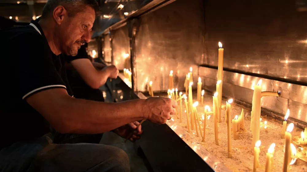 People light candles for former Bosnian Serb wartime general Ratko Mladic, in front of church in the Bosnian town of Banja Luka, 240 kms. (140 miles) northwest of Sarajevo, Thursday, August. 27, 2026. (AP Photo/Radivoje Pavicic)