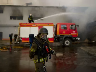 Firefighters try to extinguish a fire at a destroyed warehouse after Russian drone attacks on the outskirts of Kyiv, Ukraine, Friday, Aug. 28, 2026. (AP Photo/Francisco Seco)