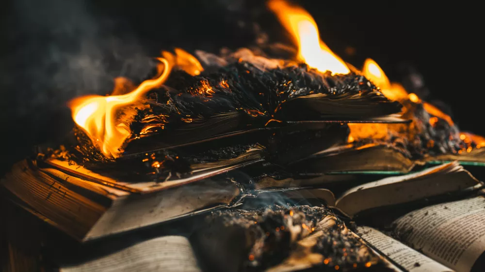 Open book is on fire, pages are engulfed in flames. Concept of censorship, prohibition of freedom information, 451 fahrenheit, old literature in paper format is no longer in demand. High photo