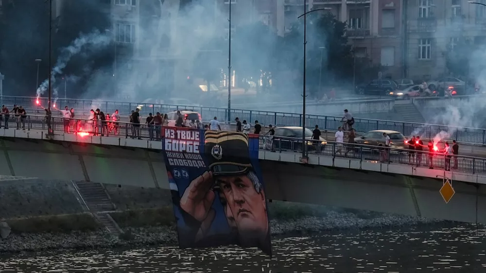 Supporters of the deceased Bosnian Serb general Ratko Mladic hold his picture and light flares on the Varadinski Bridge In Novi Sad Serbia, Serbia, August 27, 2026. REUTERS/Stefan Stojanovic