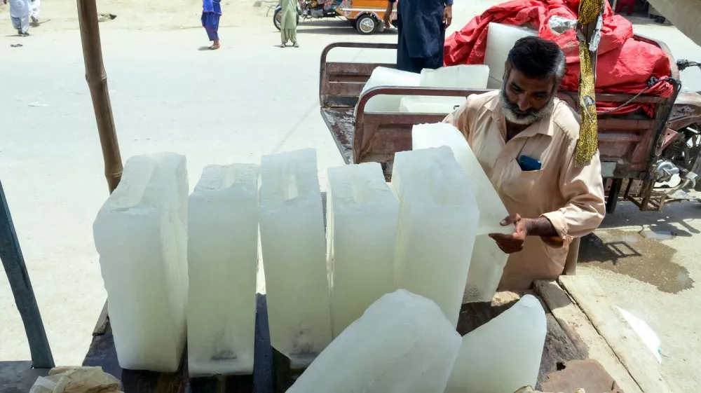 A roadside vendor unloads ice blocks from a vehicle on a hot summer day in Jaffarabad, Balochistan province on May 24, 2025.,Image: 1002936637, License: Rights-managed, Restrictions:, Model Release: no 