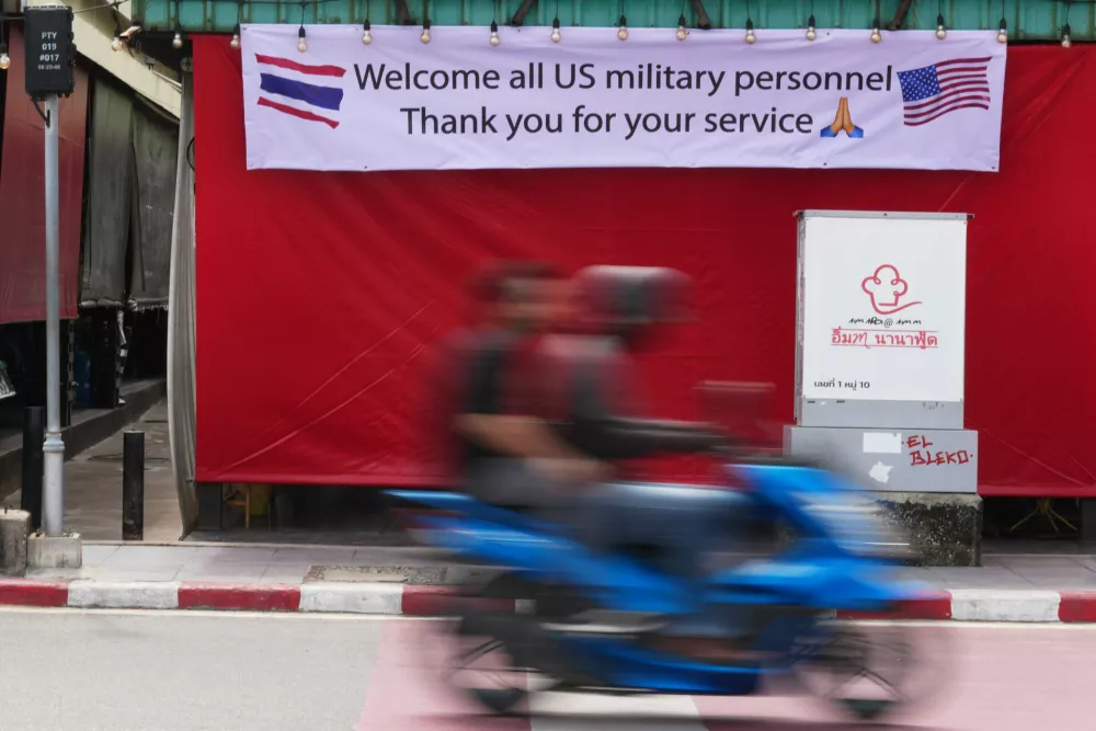 A motorcycle taxi drives past a banner in Pattaya, Thailand, Tuesday, Sept. 1, 2026. (AP Photo/Sakchai Lalit)