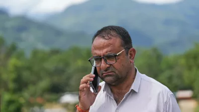 Rajendra Dawadi, a school teacher of Tribhuvan Trishuli Secondary School, talks on his mobile phone in Trishuli Valley in Nepal's Nuwakot district, Monday, Aug. 31, 2026. (AP Photo/Rajesh Kumar Singh)