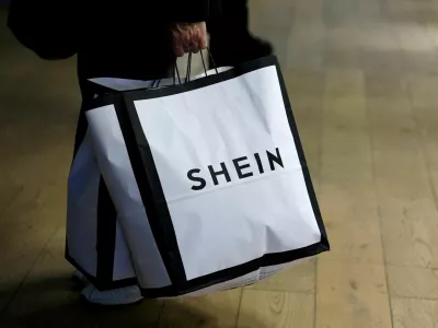 FILE PHOTO: A customer holds shopping bags with a Shein logo in the first physical space of online fast-fashion retailer Shein on the day of its opening inside the Le BHV Marais department store, the Bazar de l'Hotel de Ville, in Paris, France, November 5, 2025. REUTERS/Sarah Meyssonnier/File Photo