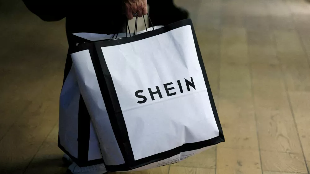 FILE PHOTO: A customer holds shopping bags with a Shein logo in the first physical space of online fast-fashion retailer Shein on the day of its opening inside the Le BHV Marais department store, the Bazar de l'Hotel de Ville, in Paris, France, November 5, 2025. REUTERS/Sarah Meyssonnier/File Photo
