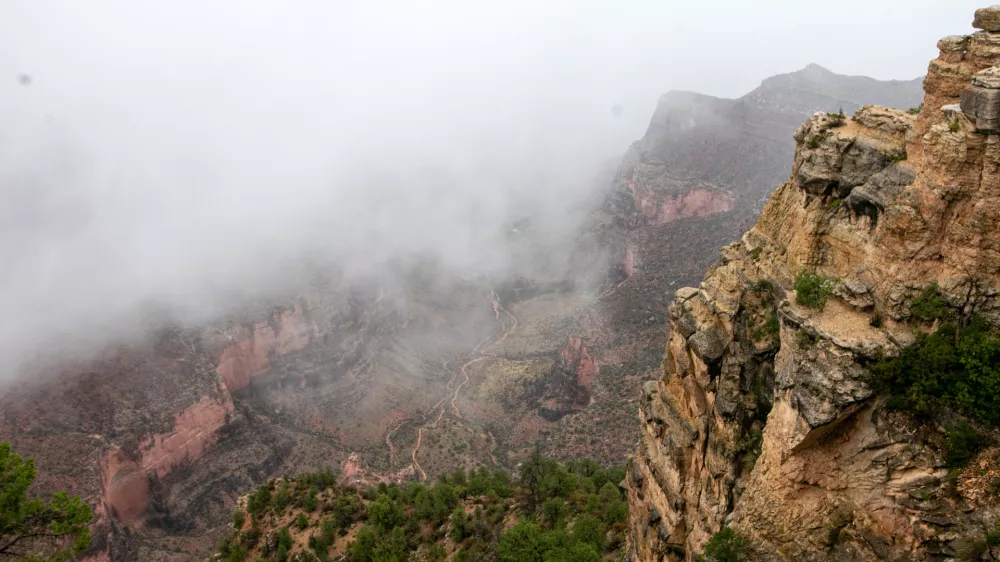 Mist and rain fall over Plateau Point in the Grand Canyon on Aug. 31, 2026, in Grand Canyon National Park, Ariz. (AP Photo/Josh Biggs)