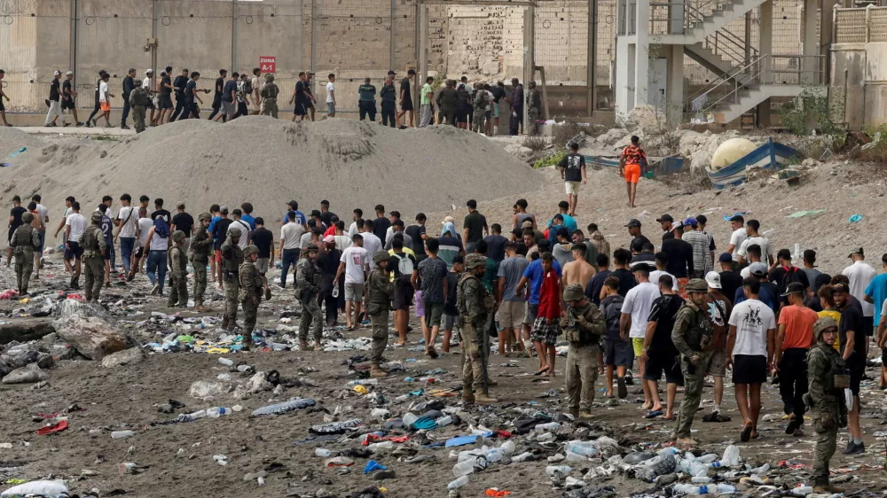 FILE PHOTO: People walk towards the border with Morocco leaving Spain, amid mass crossings of migrants on foot and by sea from Morocco into Spanish territory, in Ceuta, Spain, July 31, 2026. REUTERS/Jon Nazca/File Photo