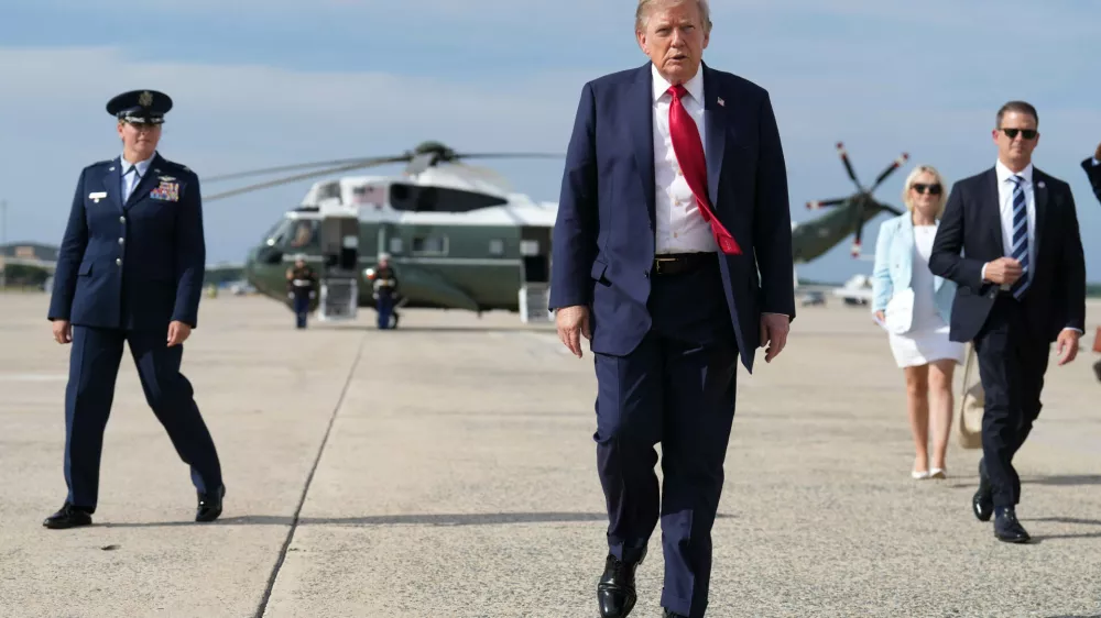 FILE - President Donald Trump, center, walks from Marine One to board Air Force One, Aug. 21, 2026, at Joint Base Andrews, Md., en route to South Carolina. (AP Photo/Jacquelyn Martin, File)