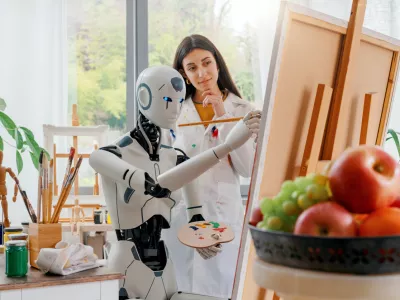 Creative AI robot learning how to paint on canvas in the art studio, a young teacher is training her