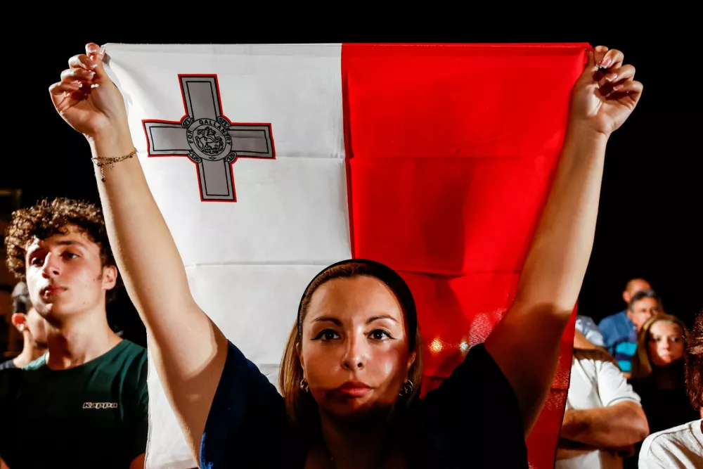 A demonstrator holds up a flag of Malta during a protest outside Auberge de Castille, the office of Malta's Prime Minister, after Maltese businessman Yorgen Fenech was acquitted of conspiracy and complicity to murder investigative journalist Daphne Caruana Galizia in 2017, in Valletta, Malta, September 2, 2026. REUTERS/Darrin Zammit Lupi   TPX IMAGES OF THE DAY