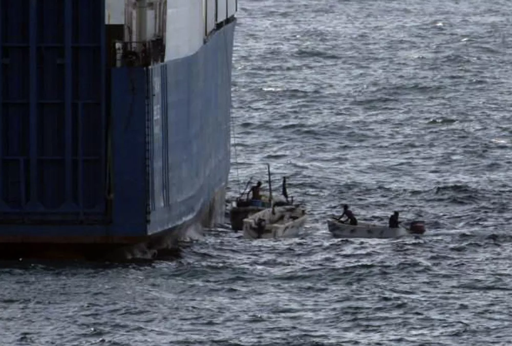 ** FILE ** In this picture released by U.S. Navy, Sunday, Sept. 28, 2008, Somali pirates in small boats are seen alongside the hijacked "Faina". Armed pirates aboard fast-moving skiffs have increasingly turned the shipping lanes off Somalia into a lucrative hunting grounds: commandeering vessels large and small and leaving the world's maritime powers frustrated about how to stop the seafaring bandits. Now, however, momentum is growing for coordinated international action to back up the sharp response after the stunning seizure late last month of a Ukrainian cargo ship laden with tanks and heavy weaponry as the pirates quickly found themselves encircled by U.S. warships and receiving only silence to their demands for millions of dollars in ransom. (AP Photo/U.S. Navy)