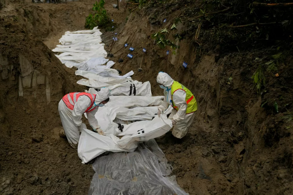 Nepal police personnel bury the bodies of flash flood victims in a mass grave in Kathmandu, Nepal, Tuesday, Sept. 1, 2026. (AP Photo/Dar Yasin)