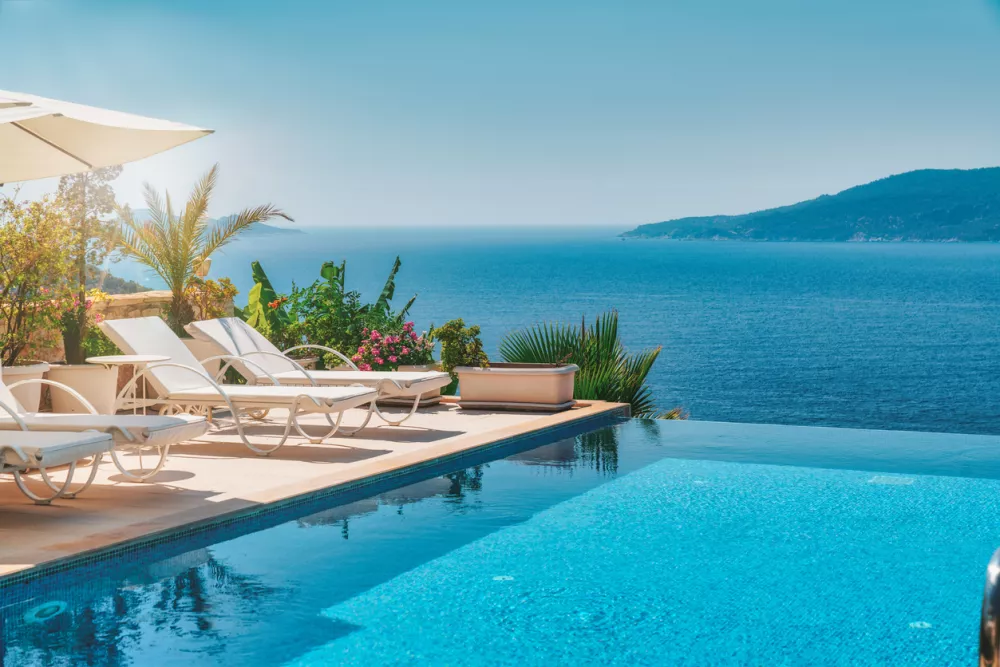 Swimming pool overlooking the sea. Summer vacation at poolside