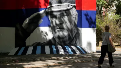 A woman walks by a mural that shows former Bosnian Serb wartime general Ratko Mladic in Belgrade, Serbia, Wednesday, Sept. 2, 2026. (AP Photo/Darko Vojinovic)
