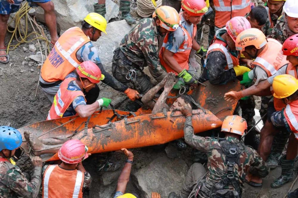 In this photo provided by the Nepal Army, soldiers rescue a worker alive from a tunnel during an ongoing operation at the Trishuli-3A hydropower project in Nepal's Rasuwa district, Friday, Sept. 4, 2026. (Nepal Army via AP)