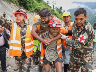 In this photo provided by the Nepal Army, soldiers rescue a worker alive from a tunnel during an ongoing operation at the Trishuli-3A hydropower project in Nepal's Rasuwa district, Friday, Sept. 4, 2026. (Nepal Army via AP)