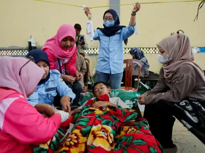 FILE PHOTO: Muhammad Setiawan Pratama, 11, an elementary student receives treatment for food poisoning after eating government-sponsored free school meals, at a makeshift clinic inside a district's hall in Bandung, West Java province, Indonesia, September 25, 2025. REUTERS/Willy Kurniawan/File Photo