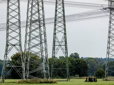 Police search the area around the extra-high-voltage power lines near the Turnow-Preilack substation and the J&auml;nschwalde power plant in Preilack, Germany, Thursday, Sept. 3, 2026 as two incidents that disrupted power distribution systems in eastern and western Germany were being investigated as possible acts of sabotage. (Frank Hammerschmidt/dpa via AP)