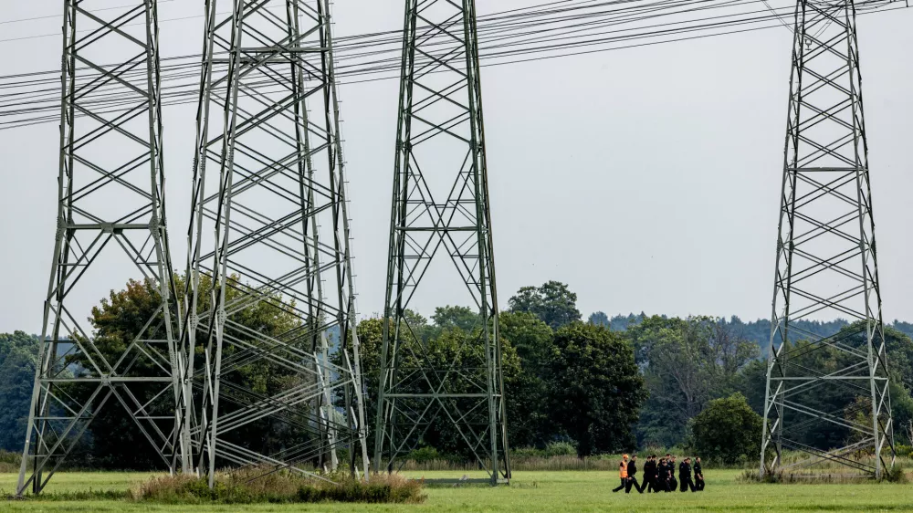 Police search the area around the extra-high-voltage power lines near the Turnow-Preilack substation and the J&auml;nschwalde power plant in Preilack, Germany, Thursday, Sept. 3, 2026 as two incidents that disrupted power distribution systems in eastern and western Germany were being investigated as possible acts of sabotage. (Frank Hammerschmidt/dpa via AP)