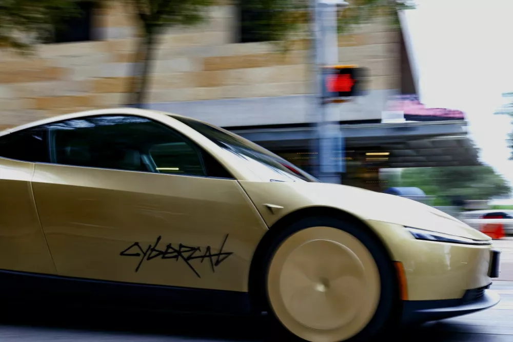 A gold-colored Tesla Cybercab arrives for an event in downtown Austin, Texas, U.S., September 3, 2026. Picture taken with a slow shutter speed. REUTERS/Kaylee Greenlee