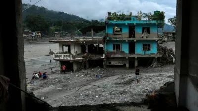 People next to damaged buildings near the Trishuli River, following the deadly flash floods and a mudslide, in Devighat, Nuwakot district, Nepal, September 4, 2026. REUTERS/Athit Perawongmetha
