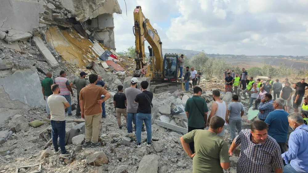 People stand amid rubble as heavy machinery operates at the site of an Israeli strike, in Arab Salim, Lebanon, September 6, 2026. Picture taken with a mobile phone. REUTERS/Ali Hankir