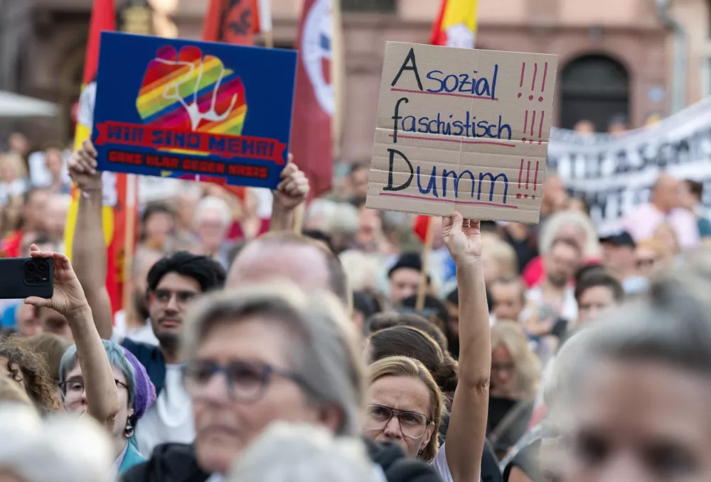 After the projections for the state election in Saxony-Anhalt were released, members of various coalitions protested against the AfD on the R&ouml;mer, holding a sign that read "Anti-social, fascist, stupid!!!", in Frankfurt, Germany, Sunday, Sept. 6, 2026. (Boris Roessler/dpa via AP)