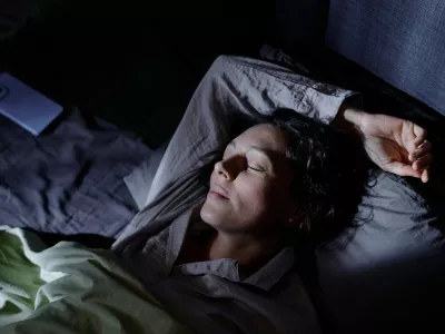Calm and content woman immersed in sweet dream, she using favorite pose to sleep in comfortable bed during whole night / Foto: Annastills Getty Images