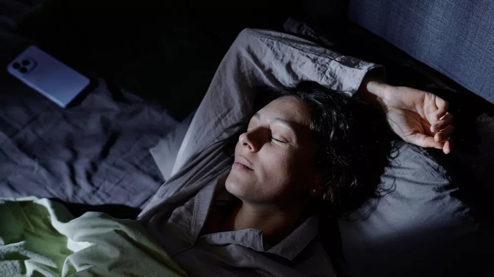 Calm and content woman immersed in sweet dream, she using favorite pose to sleep in comfortable bed during whole night / Foto: Annastills Getty Images