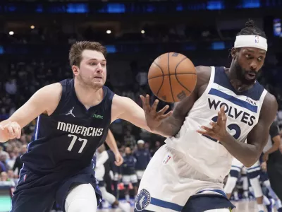 Dallas Mavericks guard Luka Doncic (77) fouls Minnesota Timberwolves guard Patrick Beverley, right, in the final seconds of the second half of an NBA basketball game in Dallas, Monday, March 21, 2022. (AP Photo/LM Otero)