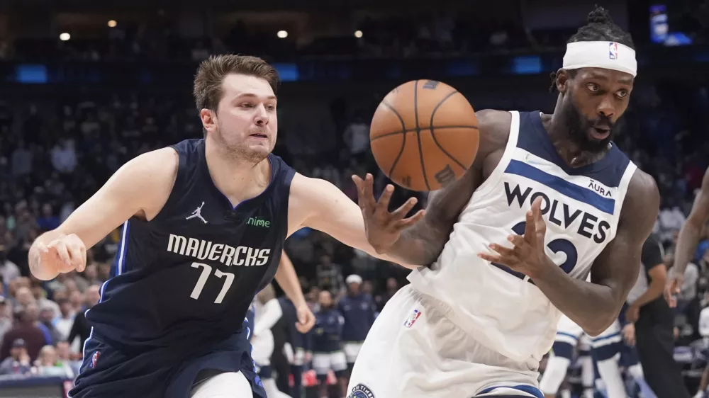 Dallas Mavericks guard Luka Doncic (77) fouls Minnesota Timberwolves guard Patrick Beverley, right, in the final seconds of the second half of an NBA basketball game in Dallas, Monday, March 21, 2022. (AP Photo/LM Otero)