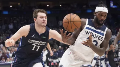 Dallas Mavericks guard Luka Doncic (77) fouls Minnesota Timberwolves guard Patrick Beverley, right, in the final seconds of the second half of an NBA basketball game in Dallas, Monday, March 21, 2022. (AP Photo/LM Otero)