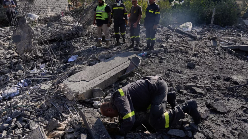 Rescue workers search for victims under the rubble of a building destroyed in an Israeli airstrike in the southern village of Kfar Rumman, Lebanon, Monday, Sept. 7, 2026. (AP Photo/Mohammed Zaatari)