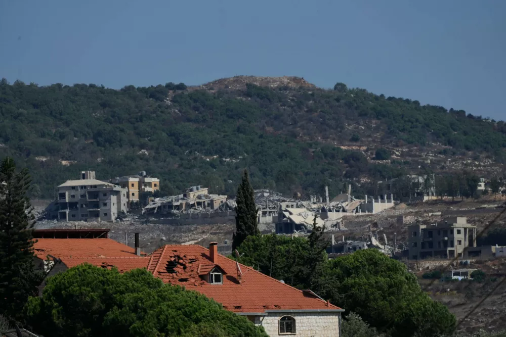 The Ali Taher Hill is seen in the background overlooking destroyed houses in the southern village of Kfar Rumman, Lebanon, Friday, Sept. 4, 2026. (AP Photo/Mohammed Zaatari)