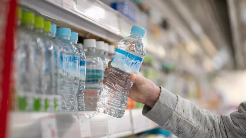 Shopper's hands buying bottled water