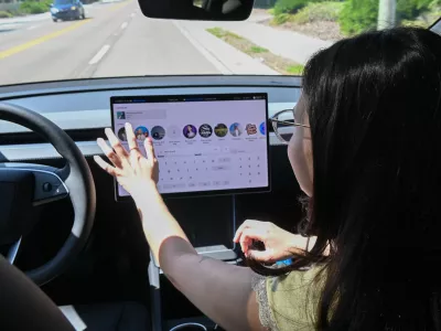Tampa Bay Times reporter Camila Gomez reaches toward the touchscreen display to select music while riding in a Tesla Robotaxi in Tampa, Florida, on August 14, 2026. Gomez was testing the autonomous vehicle service as part of a firsthand account for the Tampa Bay Times, navigating the car's center-mounted infotainment screen while the vehicle operated without a human driver on a public road.,Image: 1126106139, License: Rights-managed, Restrictions: *** World Rights *** US Newspapers Out *** NO TV, VIDEO, FILM ***, Model Release: no 