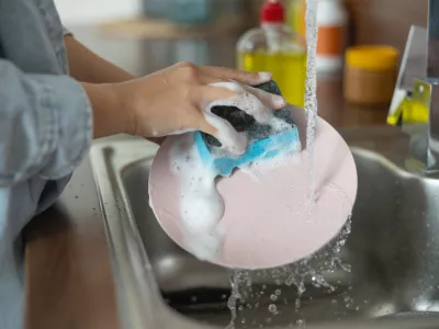Close up of female hands cleaning a dirty plate / Foto: Yacobchuk