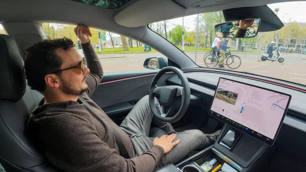 FILE PHOTO: Tesla enthusiast Kees Roelandschap drives around hands-free with his electric car, several days after Dutch regulators approved the use of Tesla's self-driving software, in Amsterdam, Netherlands, April 17, 2026. REUTERS/Bart Biesemans/File Photo