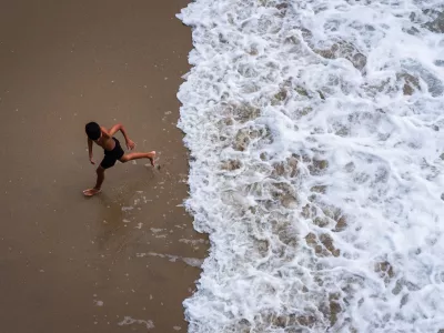 A child runs from the water as large waves from Hurricane Marie break on the shore, Monday, Sept. 7, 2026, on Huntington Beach, southern Calif. (AP Photo/Ethan Swope)
