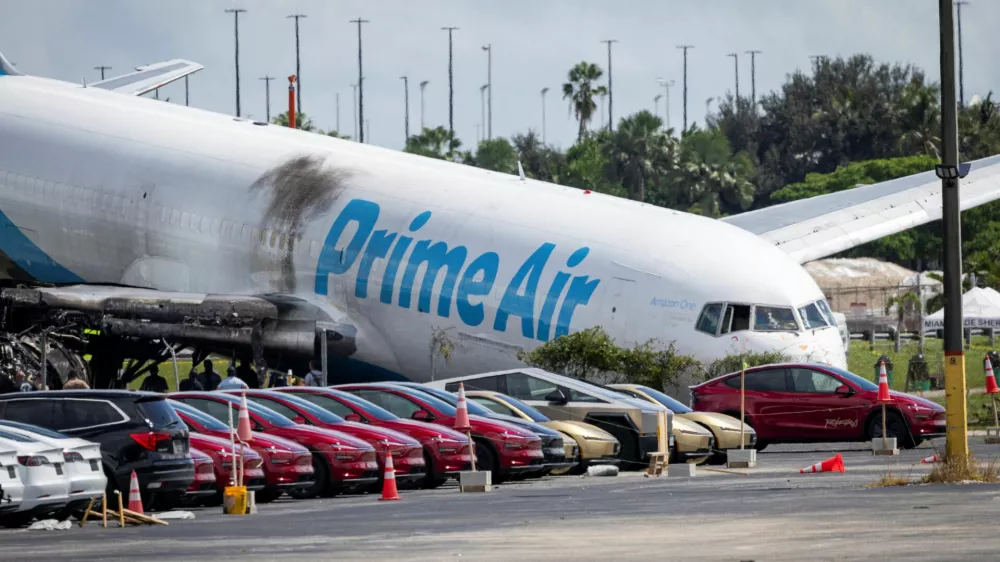 Tesla cars are parked in a lot next to where a crashed Amazon Prime Air cargo plane came to rest, where airport officials said it overran a runway at Miami International Airport, in Miami, Florida, U.S., September 7, 2026. REUTERS/Marco Bello