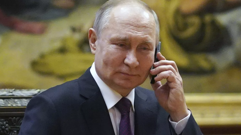 Russian President Vladimir Putin talks on the phone to eight-year-old Alexandra Titarenko from Zaporizhzhia region, a participant in the Fir Tree of Wishes charity campaign at the State Russian Museum in St. Petersburg, Russia, Tuesday, Dec. 27, 2022. (Alexey Danichev, Sputnik, Kremlin Pool Photo via AP)