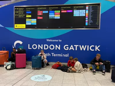 Passengers at Gatwick Airport's South Terminal sit after flights were cancelled because of a technical issue in Britain's air traffic control system Tuesday, Sept. 8, 2026, in Crawley, south of London. (Jordan Pettitt/PA via AP)